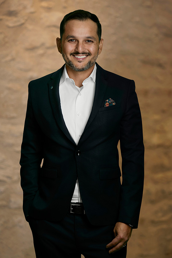 Mustafa - Skyline Wealth Management sales team leader against a Brick Background, embodying expertise in wealth advisory and business expansion.