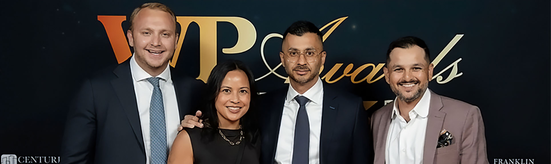 Skyline Wealth Management employees at an award gala, smiling and posing with an award trophy.